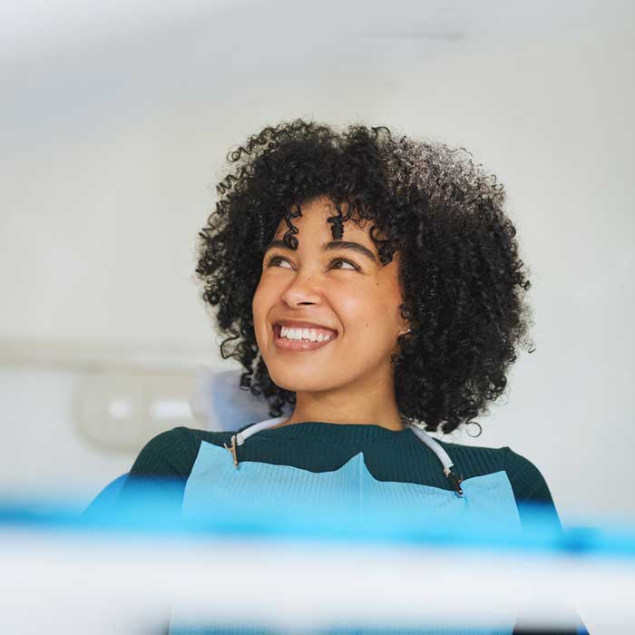 Shot of a happy young woman sitting in a dentist’s chair
