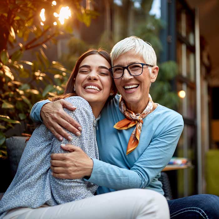 Portrait of a senior mother and adult daughter, hugging, smiling
