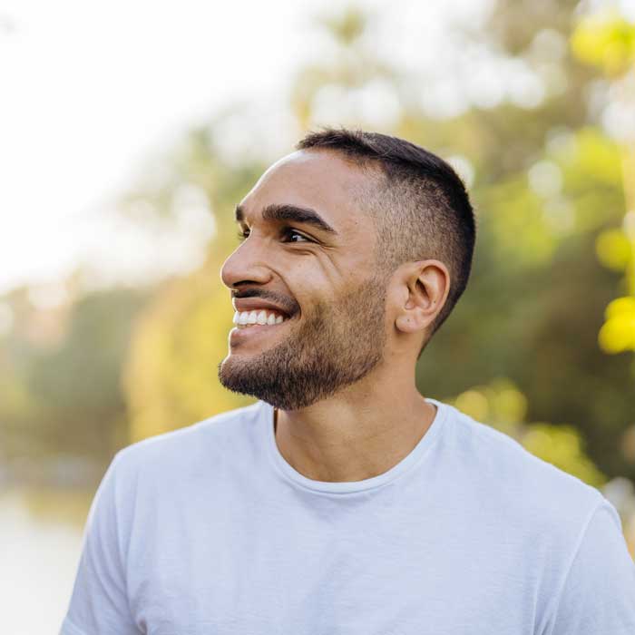 Young smiling man in public park