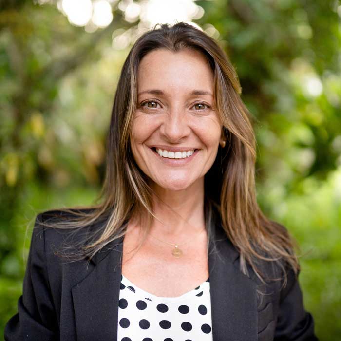 Mature woman standing outside in a park and smiling
