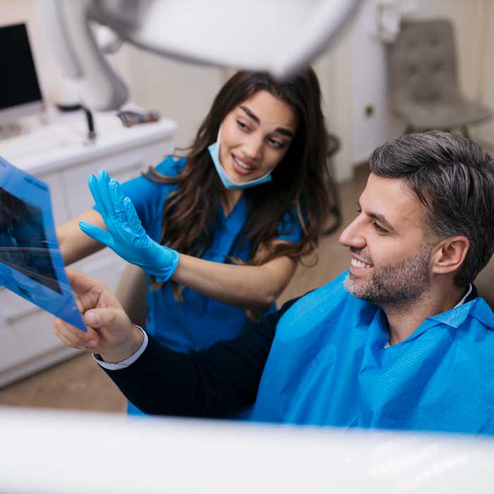 Dentist showing teeth x-ray to patient at dentistry