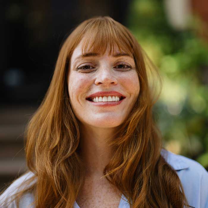 Smiling Woman with Red Hair Outdoors in Natural Light