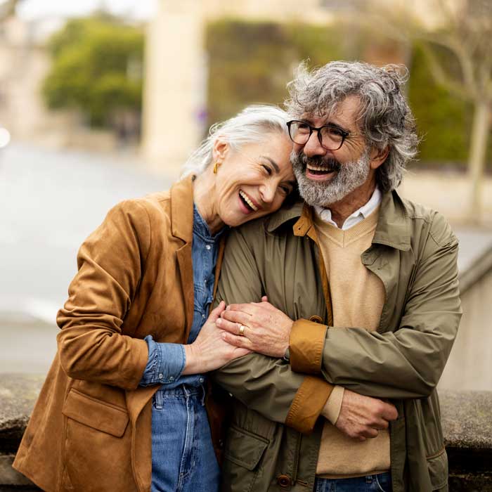 senior couple laughing and embracing outdoors