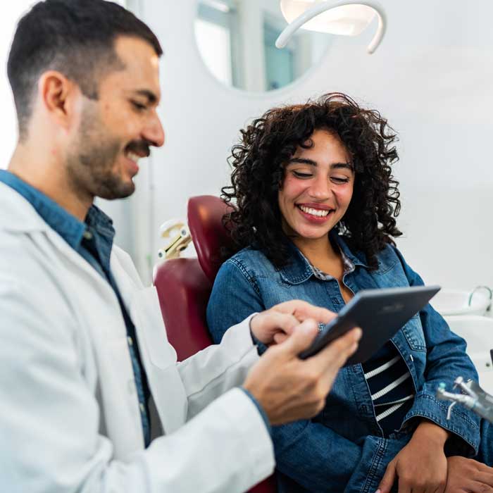 dentist showing patient something on tablet