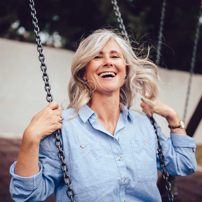 Portrait of mature woman with gray hair sitting on swing