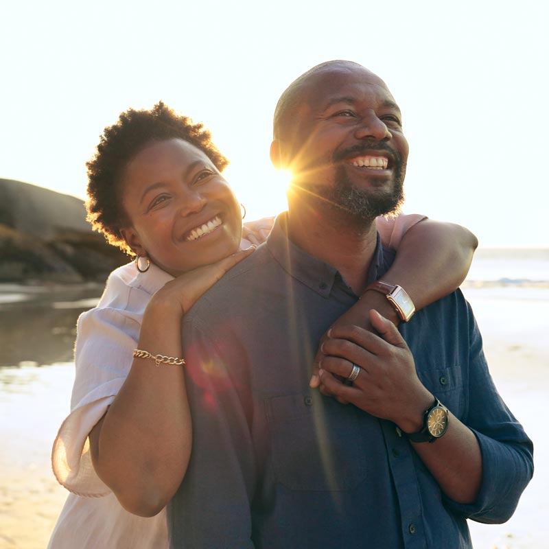 couple on the beach smiling